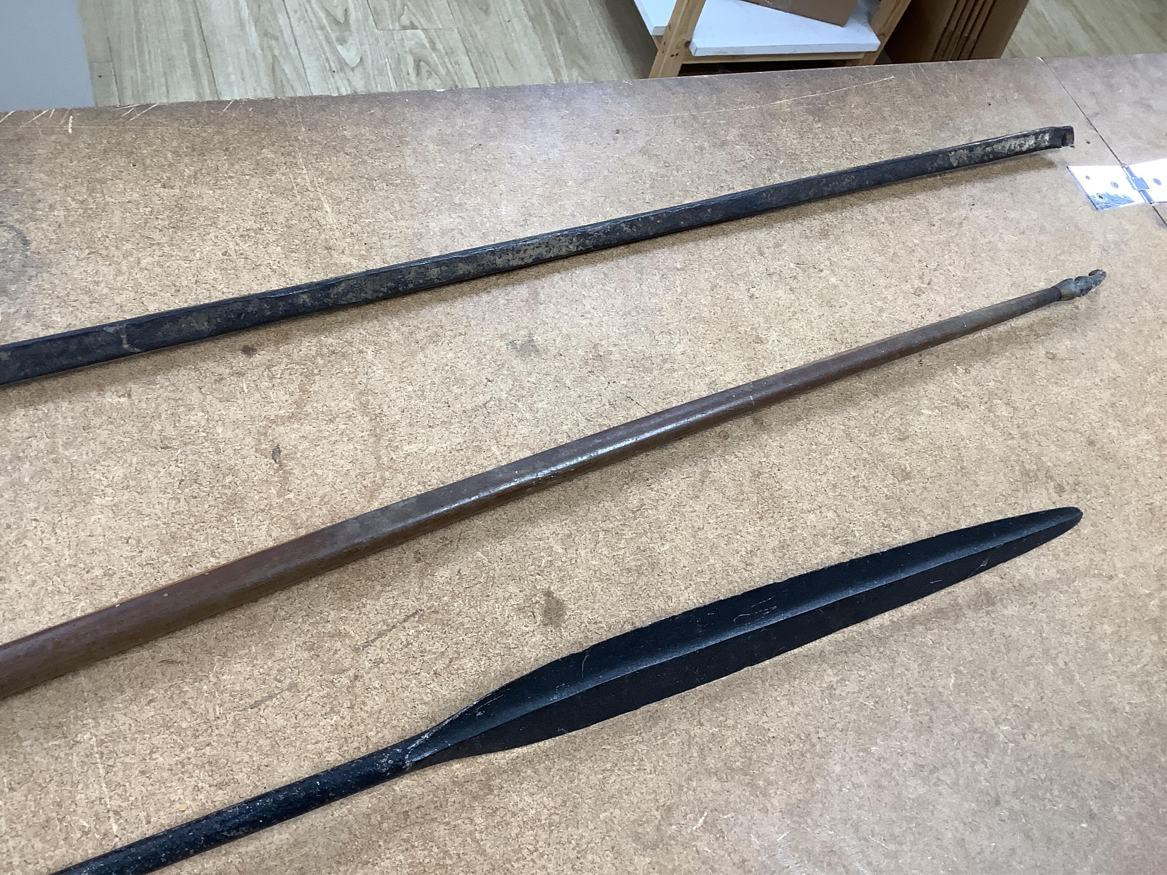 A collection of tribal spears, a fish hook, a cased snooker cue, etc.